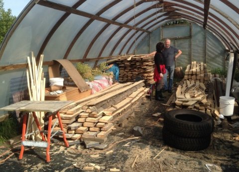 Sigurður sýnir Valgerði Erlingsdóttur skógræktarráðgjafa stafla af flettum viði í viðarskýli í Giljalandi. Mynd: Björn Bjarndal Jónsson.