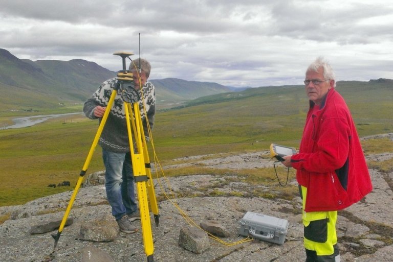 Dróninn með myndavélinni er góð viðbót við hefðbundin landmælingatæki, hæðar- og fjarlægðarmæla, staðsetningartæki og þess háttar. Hér sjást þeir Pål (f.v.) og Thore við mælingar í Austur-Húnavatnssýslu. Þeir standa á Hólsbergi sunnan við bæinn Kagaðarhól (sjónarhóll) og myndatökumaðurinn við sjáum fram Langadal og Bakása, bærinn Fagranes Langadalsmegin í forgrunni og Gunnfríðarstaðaskógur hinn fjölbreytti Bakásameginn. Á Hólsbergi er Svarthamar við Blöndu og þar voru menn hengdir fyrrum. Sunnar og neðar er Mjósund en þar var áður ferjustaður yfir Blöndu og ein aðalpóstleiðin..