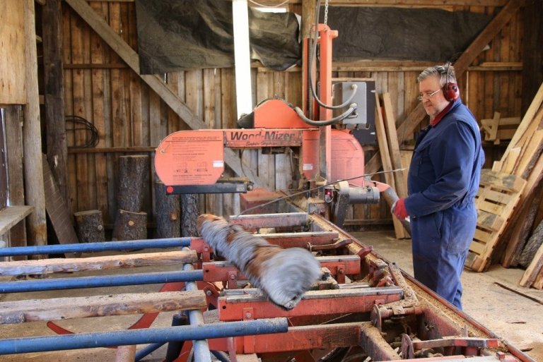 Jón Þór Tryggvason flettir bol í sögunarmyllunni á Hallormsstað.