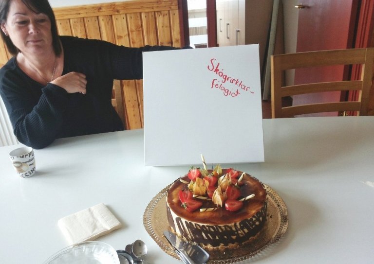 Vala Garðarsdóttir með tertuna góðu sem merkt var „Skógræktarfélagið“.<br />
Mynd: Þröstur Eysteinsson