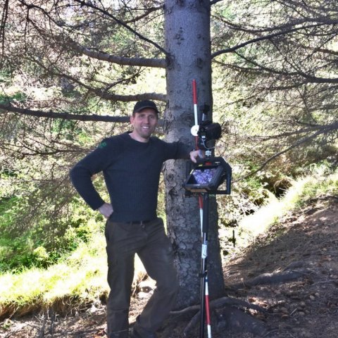 Björn Traustason, landfræðingur á Mógilsá, rannsóknasviði Skógræktarinnar, við hæsta tréð með nákvæm mælitækin sem notuð voru við mælingarnar. Ljósmynd: Britta Sterner.