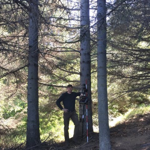 Björn Traustason, landfræðingur á Mógilsá, rannsóknasviði Skógræktarinnar, við hæsta tréð. Ljósmynd: Britta Sterner.