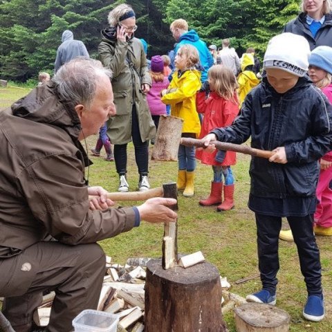Óli Odds kennir ungum skógarmanni að kljúfa eldivið. Ljósmynd: Hreinn Óskarsson