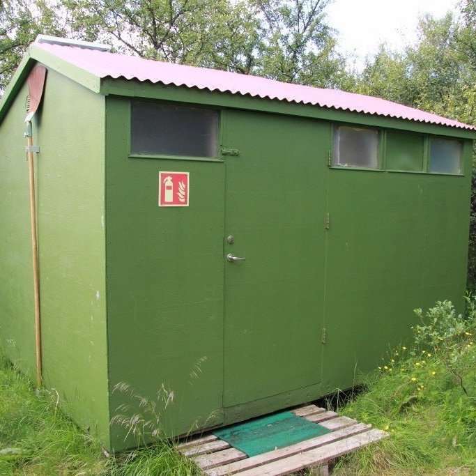 Búnaður til fyrstu slökkvistarfa þarf að vera aðgengilegur öllum, reyk- og gasskynjarar í hjólhýsum, slökkvitæki og klöppur eins og sú sem hér sést á gafli þessa þjónustuhúss. Slíkar klöppur ættu að vera til taks við hvert einasta hjólhýsi. Með þeim má slökkva litla gróðurelda, til dæmis í sinu, áður en þeir ná að breiðast út og verða óviðráðanlegir.. Ljósmynd: Pétur Halldórsson