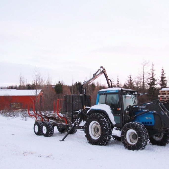 Hér er Jóhannes að afferma viðarvagninn. Vesturhlið nýju skemmunnar sést í baksýn.. Ljósmynd: Pétur Halldórsson