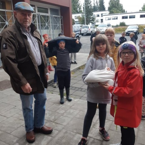 Þröstur Eysteinsson skógræktarstjóri tekur við fræinu sem hann lofar að fari á góðan stað í nágrenninu. Ljósmynd: Egilsstaðaskóli