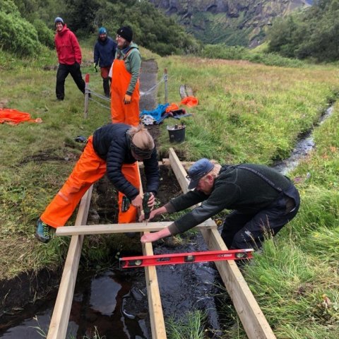 Vandað til verka við brúarsmíði á blautum kafla. Charles J Goemans, verkefnastjóri sjálfboðahópa á Þórsmörk, lengst til hægri. Ljósmynd: Nicolas Talou