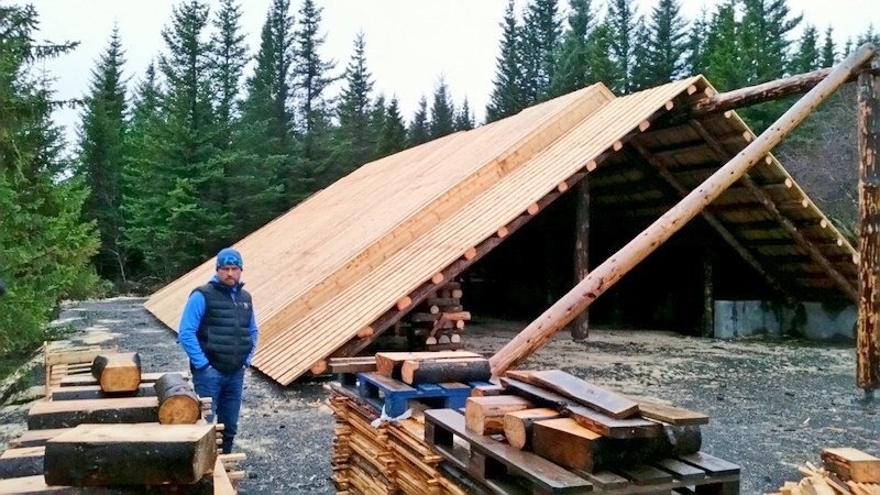 Byggingameistari hússins, Ívar Örn Þrastarson, stendur við bálskýlið sem nú er komið undir þak.